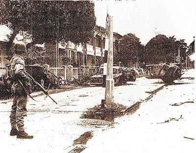 513-5月16日，一名武装人员正在暴徒汇集的甘榜峇鲁禧街（Jln Hale）上镇守