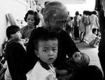513- 5月18日，在默迪卡体育馆内设立的难民中心里，一名华裔老妇正在抚慰小孩。