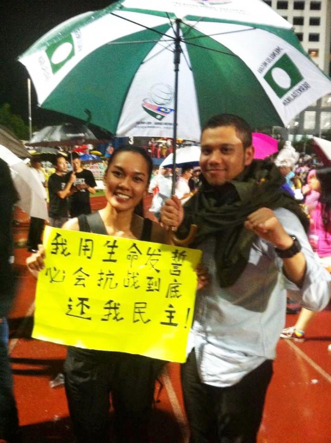 Carmen Yew：  我站在雨中举牌子很久了 突然有个马来同胞走过来为我撑伞 一直到雨停. 谢谢你 我真的感动 我们都是一家人.