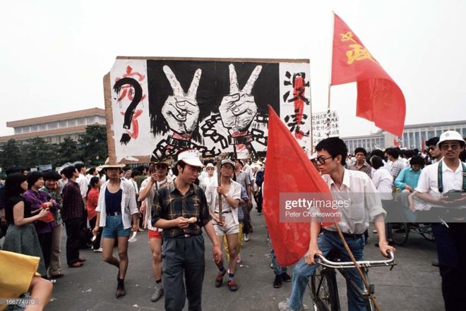 BEIJING, CHINA - 1989/06/01: Pro-democracy demonstrators carry huge banners and flags of protest as they and thousands of other protestors march down Changan Avenue past Tiananmen Square. Pro-democracy demonstrators and protestors filled the square for weeks prior to the final nighttime Communist Government's bloody crackdown.. (Photo by Peter Charlesworth/LightRocket via Getty Images)