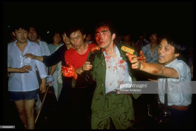 Dazed soldier covered in blood from head wound being helped and escorted by pro-democracy student protestors; Tiananmen Sq. (Photo by Forrest Anderson/The LIFE Images Collection/Getty Images)