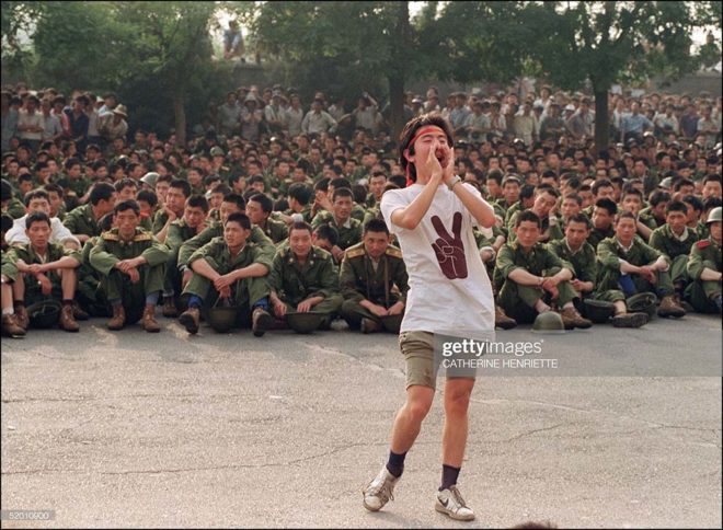 BEIJING, CHINA - JUNE 3: A dissident student asks soldiers to go back home as crowds flooded into the central Beijing 03 June 1989. On the night of 03 and 04 June 1989, Tiananmen Square sheltered the last pro-democracy supporters as Chinese troops marched on the square to end a weeks-long occupation by student protestors, using lethal force to remove opposition it encountered along the way. Hundreds of demonstrators were killed in the crackdown as tanks rolled into the environs of the square. AFP PHOTO (Photo credit should read CATHERINE HENRIETTE/AFP/Getty Images)