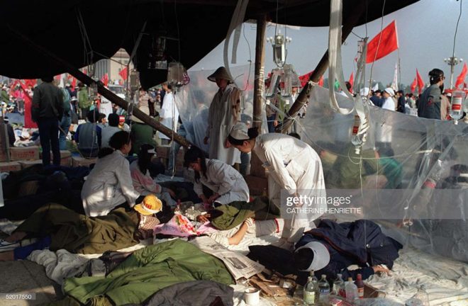 BEIJING, CHINA - MAY 17: Ailing student hunger strikers from Beijing University receive first-aid treatment under a makeshift tent set up 17 May 1989 at Tiananmen Square as students enter the 5the day of a marathon hunger strike as the part of mass pro-democracy protest against the Chinese government. The April-June1989 pro-democracy movement was crushed by Chinese troops in June 1989 when army tanks rolled into Tiananmen Square 04 June. (Photo credit should read CATHERINE HENRIETTE/AFP/Getty Images)