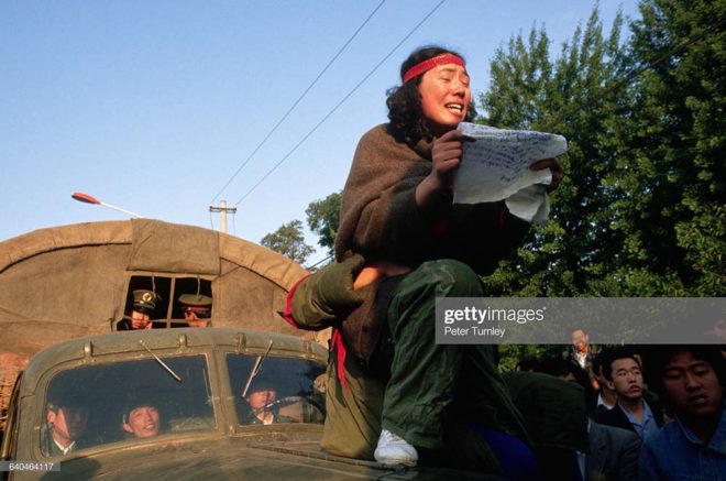 A demonstrator reads aloud from the hood of a military truck during a student protest in Tiananment Square. (Photo by Peter Turnley/Corbis/Getty Images)