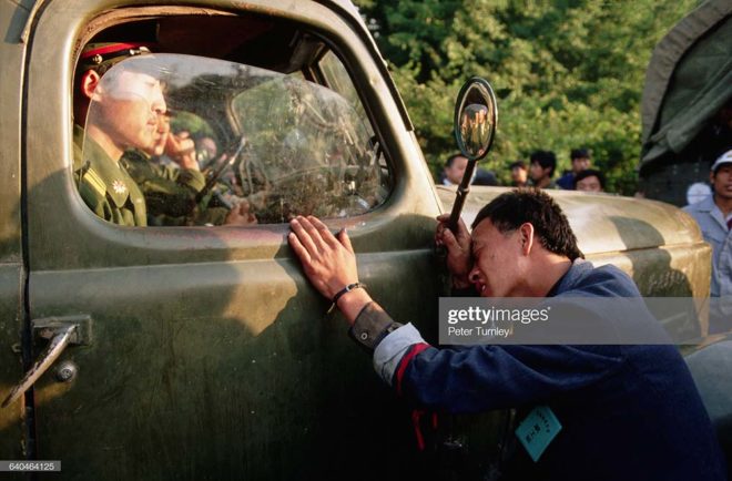 A weary protester pleads with a PLA officer sitting in his truck to not crackdown on the student demonstrators in Tiananmen Square. (Photo by Peter Turnley/Corbis/Getty Images)